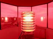 A digital light flashes inside the Beaver Island Harbor Light, known as the Whiskey Point Light, on Beaver Island, Mich., Friday, July 14, 2023. The lighthouse was built in 1870 and remains an active navigational aid for vessels on Lake Michigan. Its windows are tinted red. (Garret Ellison | MLive)